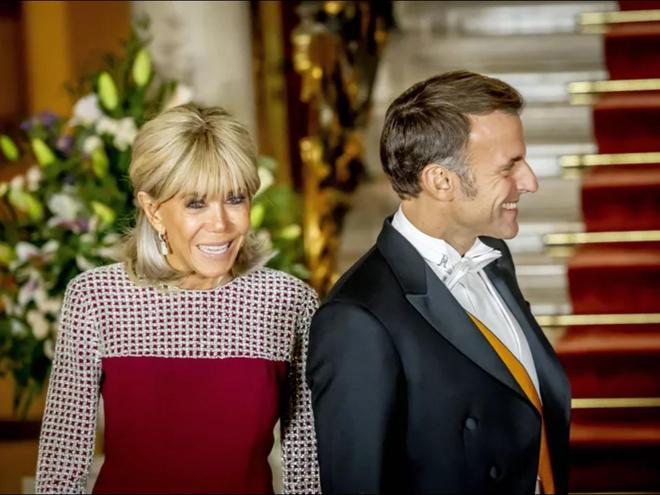 布丽吉特晚宴造型绝美酒红色礼服妩媚动人跟帅气丈夫手牵手